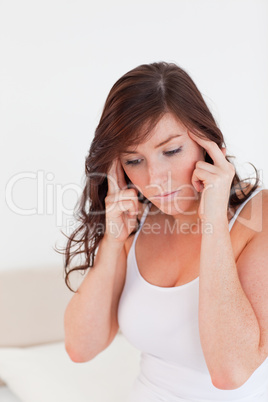 Attractive brunette woman having a headache while sitting