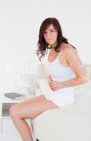 Good looking brunette woman having a stomach ache while sitting