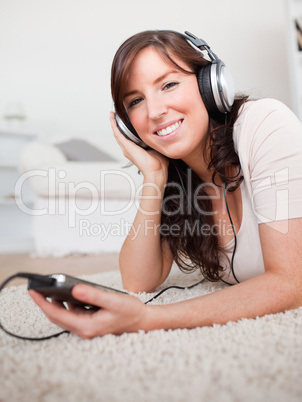 Gorgeous brunette woman listening to music with her mp3 player w