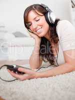 Charming brunette woman listening to music with her mp3 player w