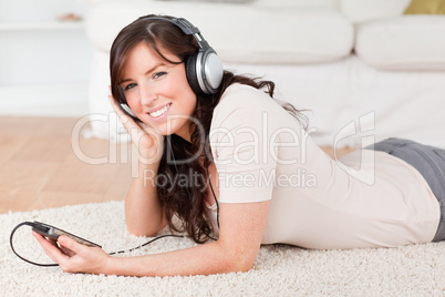 Attractive brunette female listening to music with her mp3 playe