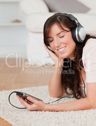 Good looking brunette female listening to music with her mp3 whi