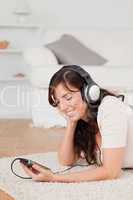 Pretty brunette female listening to music with her mp3 player wh