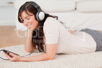 Gorgeous brunette female listening to music with her mp3 player