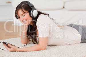 Gorgeous brunette female listening to music with her mp3 player