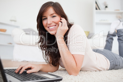 Charming brunette woman on the phone while relaxing with her lap