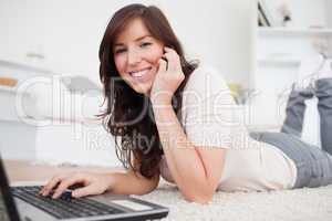 Charming brunette woman on the phone while relaxing with her lap