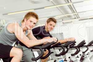 Fitness young man on gym bike spinning