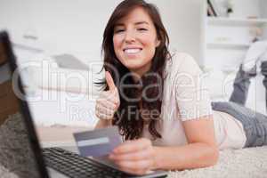 Young cute woman making a payment with a credit card on the inte