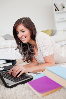 Young good looking woman relaxing with her laptop while lying on