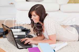 Young happy woman relaxing with her laptop while lying on a carp