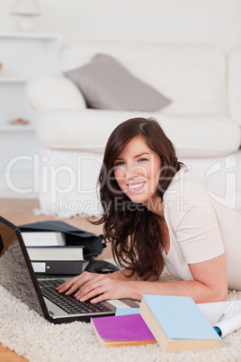 Young gorgeous woman relaxing with her laptop while lying on a c