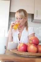 young blond woman drinks out of a glass