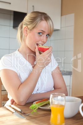 young blond woman bites off from an apple