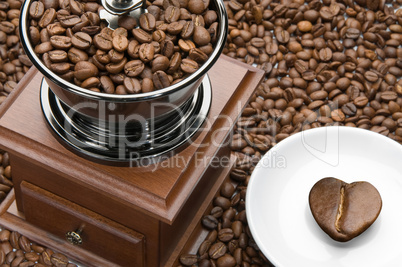 Old coffee grinder and heart on a saucer