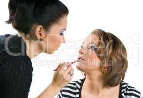 Makeup artist applying lipstick using lip concealer brush