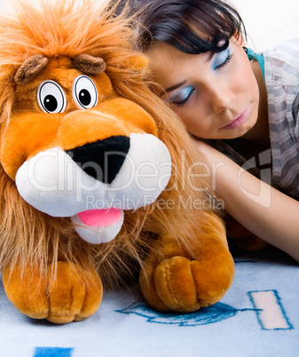 Beautiful sleeping girl with her Plush lion