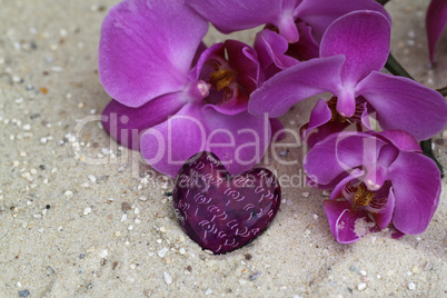 Orchideenblüte mit  Herz im Sand