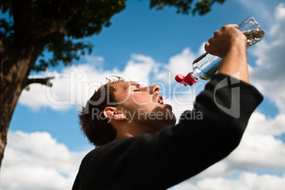 Sportsman drinking water after training