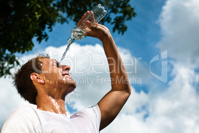 Sportsman throwing water over his head for refreshment