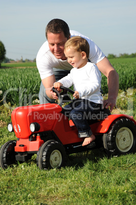 Vater und Sohn mit rotem Traktor