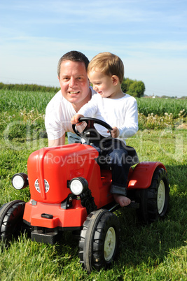 Vater und Sohn mit rotem Traktor