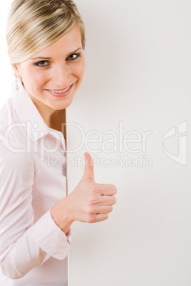 Happy businesswoman behind empty banner thumbs up