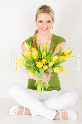 Happy woman hold bunch of tulips sitting