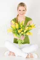 Happy woman hold bunch of tulips sitting