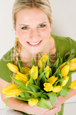 Young happy woman hold yellow tulips flower