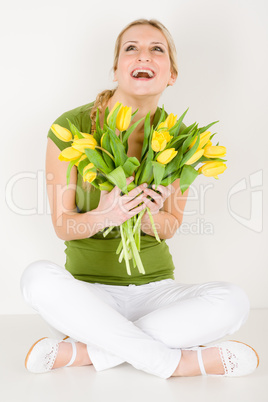 Happy woman hold bunch of tulips sitting