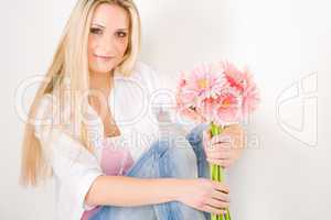 Young woman hold pink gerbera daisy flower