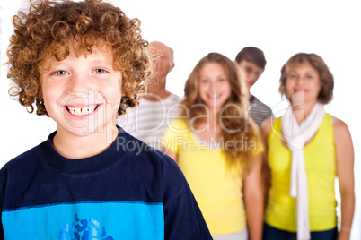 Adorable young kid in focus with family in the background