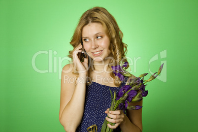 Woman on the phone and holds a bouquet of flowers