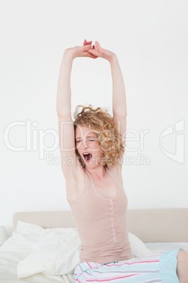 Beautiful blonde female stretching in her bedroom