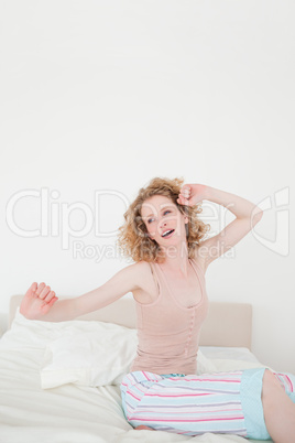 Cute blonde female stretching in her bedroom