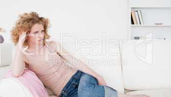 Attractive blonde woman relaxing while sitting on a sofa