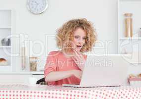 Attractive blonde female relaxing with her laptop while sitting