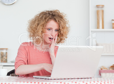 Good looking blonde female relaxing with her laptop while sittin