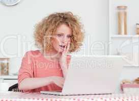 Good looking blonde female relaxing with her laptop while sittin