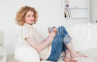 Charming blonde female enjoying a cup of coffee while sitting on