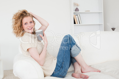 Good looking blonde woman enjoying a cup of coffee while sitting
