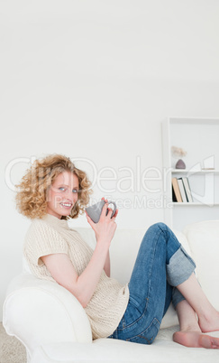 Beautiful blonde woman enjoying a cup of coffee while sitting on