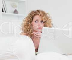 Lovely anxious female relaxing with her laptop while sitting on