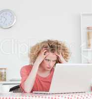 Lovely blonde female being angry while relaxing with her laptop