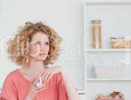 Attractive blonde woman drinking a cup of coffee while sitting i