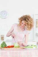 Good looking blonde woman cooking some vegetables in the kitchen