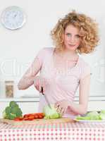 Attractive blonde woman cooking some vegetables in the kitchen