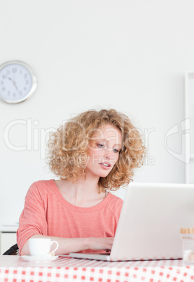 Good looking blonde woman relaxing with her laptop while sitting