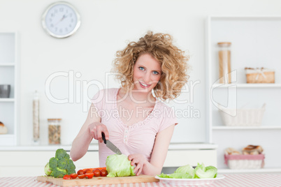 Pretty blonde woman cooking some vegetables in the kitchen